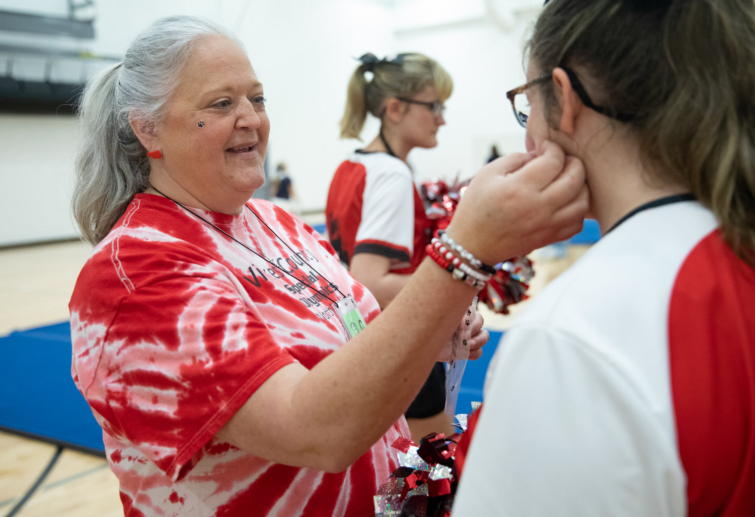 Coaches help cheerleaders with costumes and makeup before performing routines at the Special Olympics N.C. Cheerleading competition at Seaforth High School.